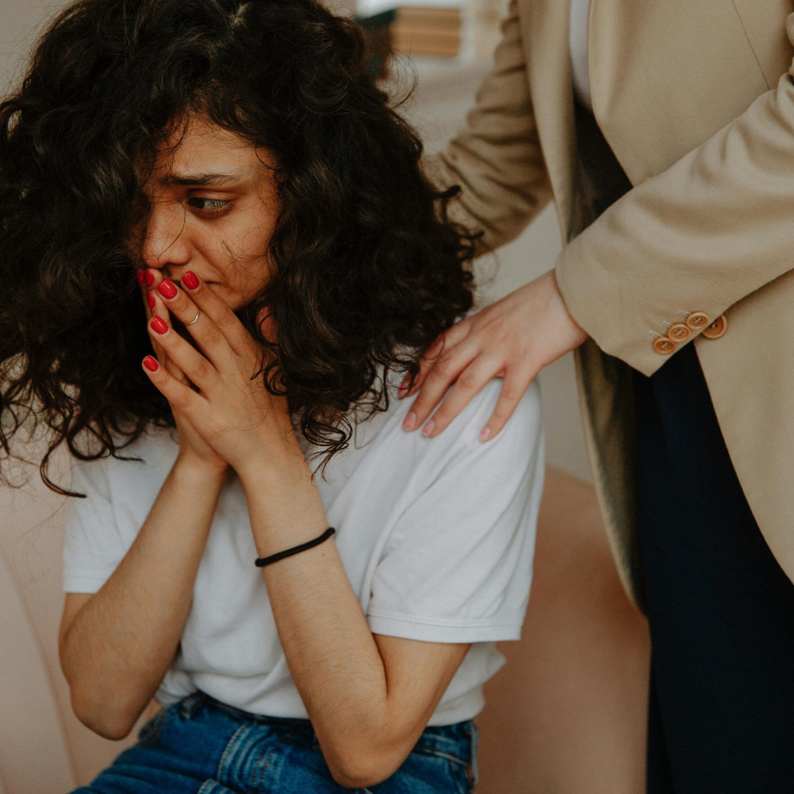 A young woman receiving comforting support in a counseling session.